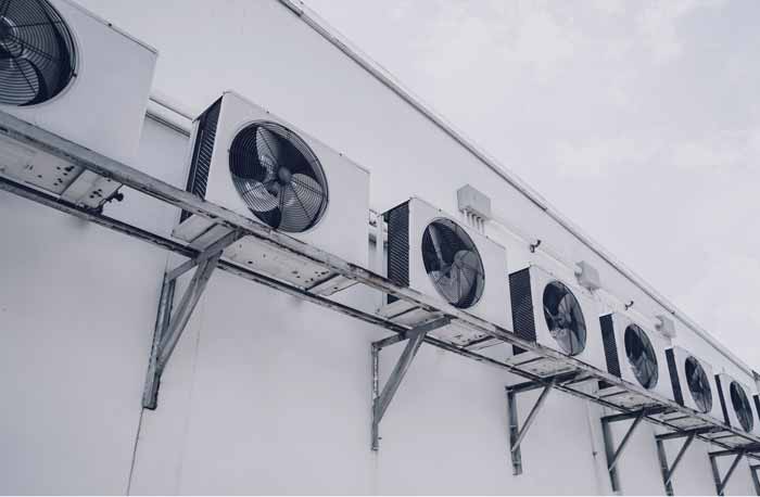 Ventilateurs industriels en exterieur derrière un hangar